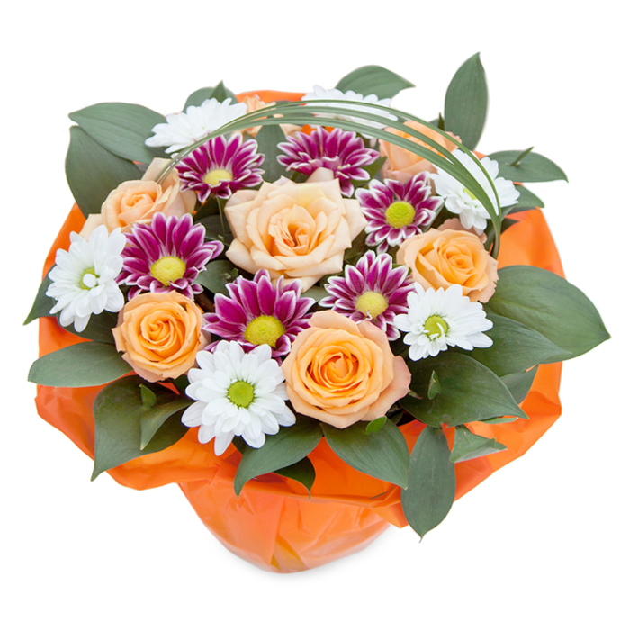 From a bird's eye view, this artful bouquet reveals a celebration of nature's beauty, finely crafted by an experienced florist in the heart of Norbiton. The central roses create a glowing core, their soft peach to orange gradient symbolising warmth and gentle affection. These roses are surrounded by distinctive chrysanthemums in two forms: the snowy, daisy-like whites with pale yellow-green centres, and the rich magenta blooms, each encircling brilliant lime-green eyes, infusing the arrangement with a vibrant energy that echoes the spirited atmosphere of local Norbiton markets. Glossy, dark green broadleaf foliage provides a luxurious, enveloping backdrop, enhancing the brilliance of each bloom and adding a lush sense of depth-reminiscent of Norbiton's hidden gardens and pocket parks in summertime. The clever inclusion of a fine, arching ribbon of bear grass offers an elegant, dynamic contrast, its gentle curve suggesting movement and grace. At the base, the bouquet is neatly gathered and wrapped in tangerine-orange cellophane, accentuating the warm hues above and presenting the arrangement as a thoughtful, ready-to-gift offering. The composition's interplay of bold and subtle colours, dense greens, and delicate contours demonstrates both technical mastery and a heartfelt understanding of Norbiton's love for fresh, joyful flowers. The bouquet's glowing presence stirs feelings of appreciation, celebration, and well-being, making it a cherished choice for gifting, event decoration, or bringing an elevated sense of cheer to local homes.